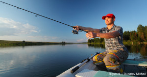 Man fishing from a boat at sunset