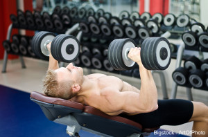 Muscular Young Man Shirtless, Training Pecs On Gym Bench